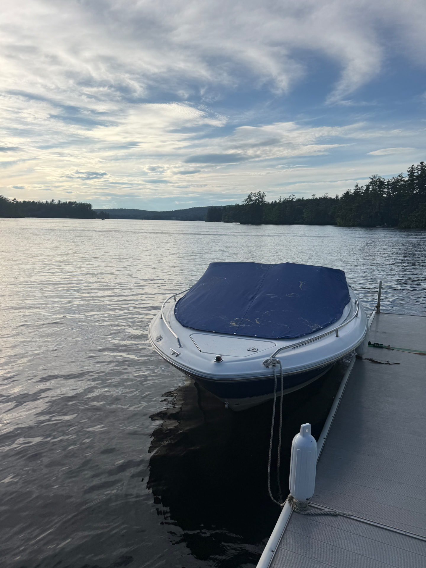 Sea Ray 210 covered and tied up at the dock at sunset on a New Hampshire lake